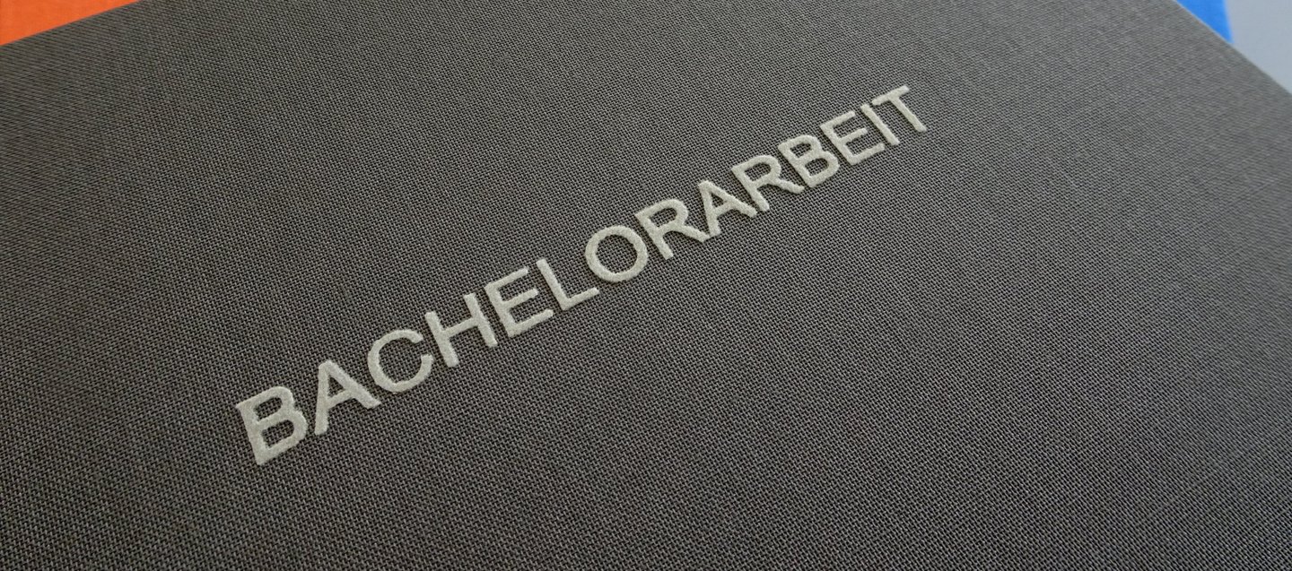 Nahaufnahme einer Abschlussarbeit mit der Aufschrift Bachelorarbeit.