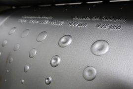 Prägewalze mit verschiedenen geometrischen Elementen zur Oberflächenstrukturierung.