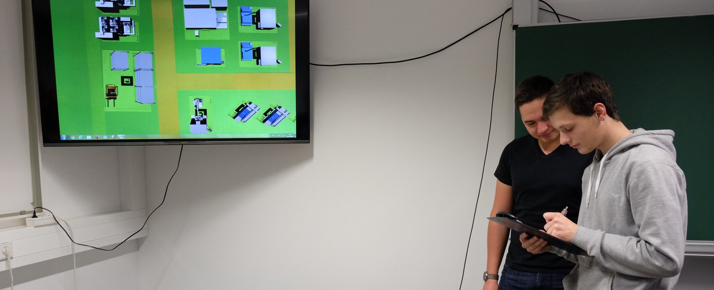 Zwei Studierende bei der Anwendung des digitalen 3D-Fabrikmodells.